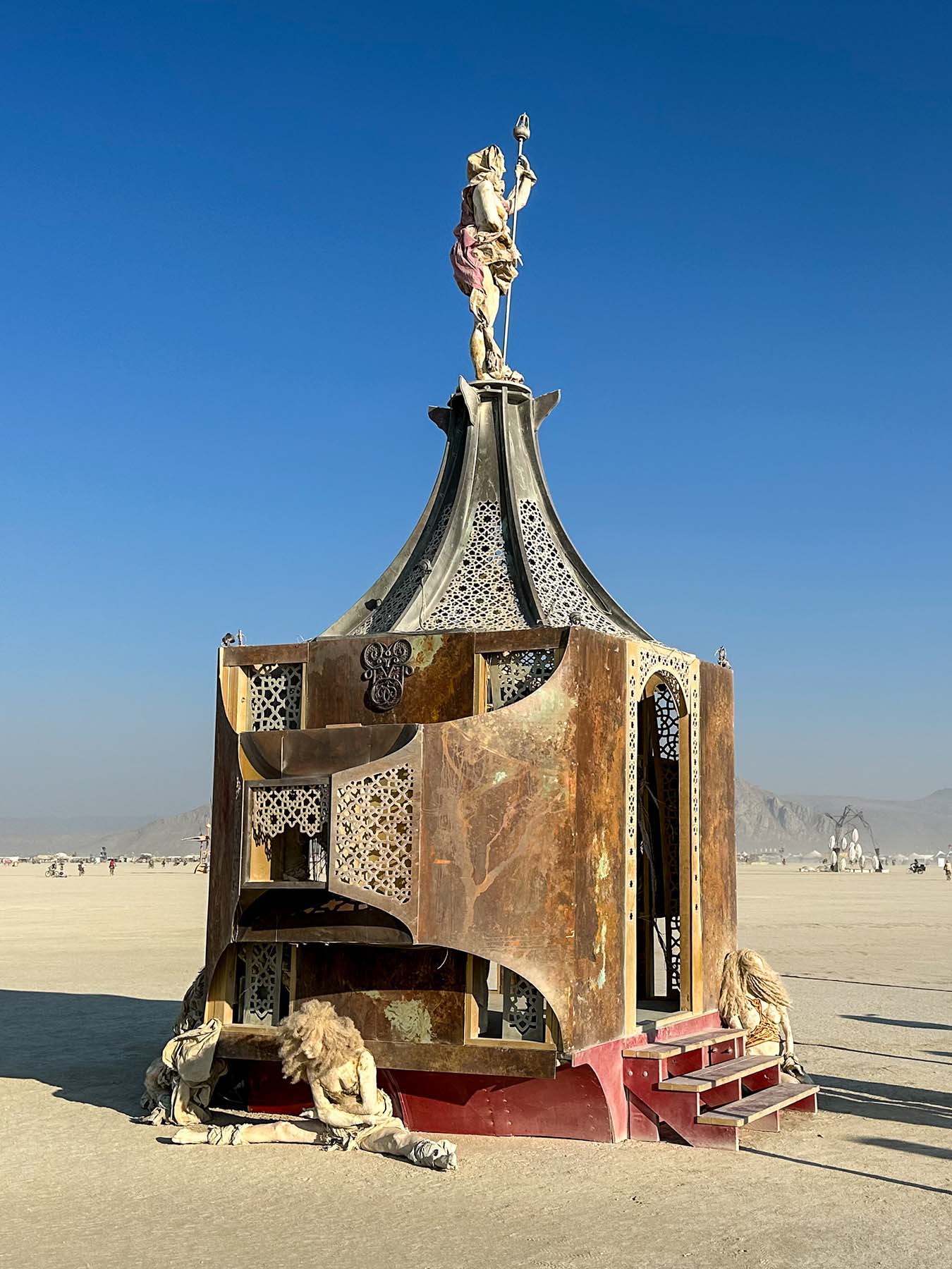 Side view of the rusted pavilion and its ornate roof against a clear blue sky in daylight