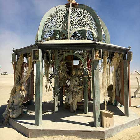 Close view of the pavilion's pierced metal dome and the cast figures inside