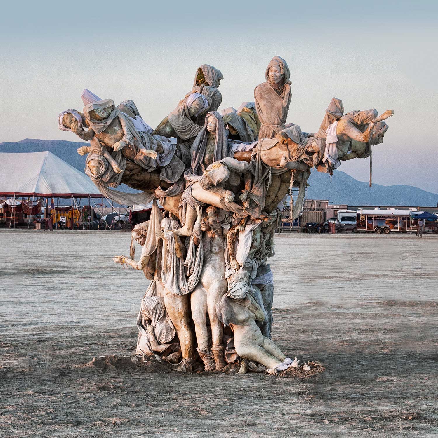 Womantree on the open playa by day, with a large white tent and camps behind it