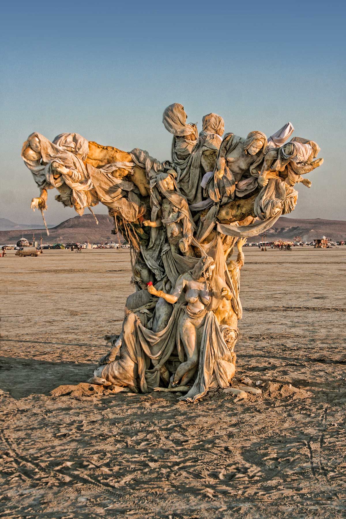 Womantree at golden hour, its canopy of cast figures catching the warm light above the playa