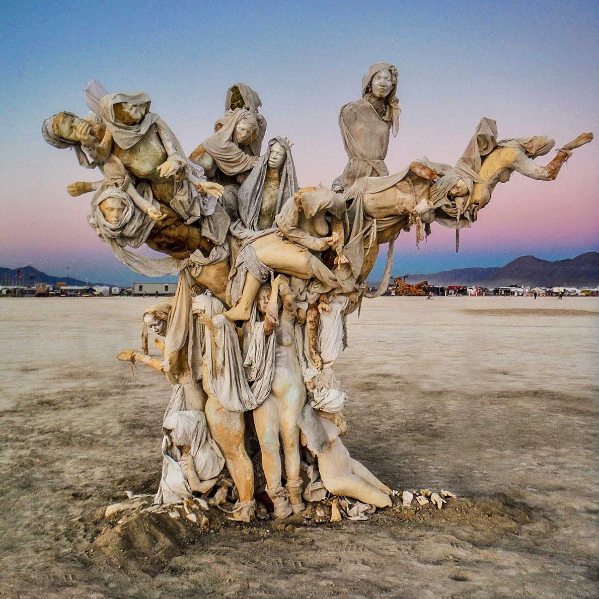 Womantree under a pink and blue dusk sky, figures stretching outward from its crown above a trunk of standing women