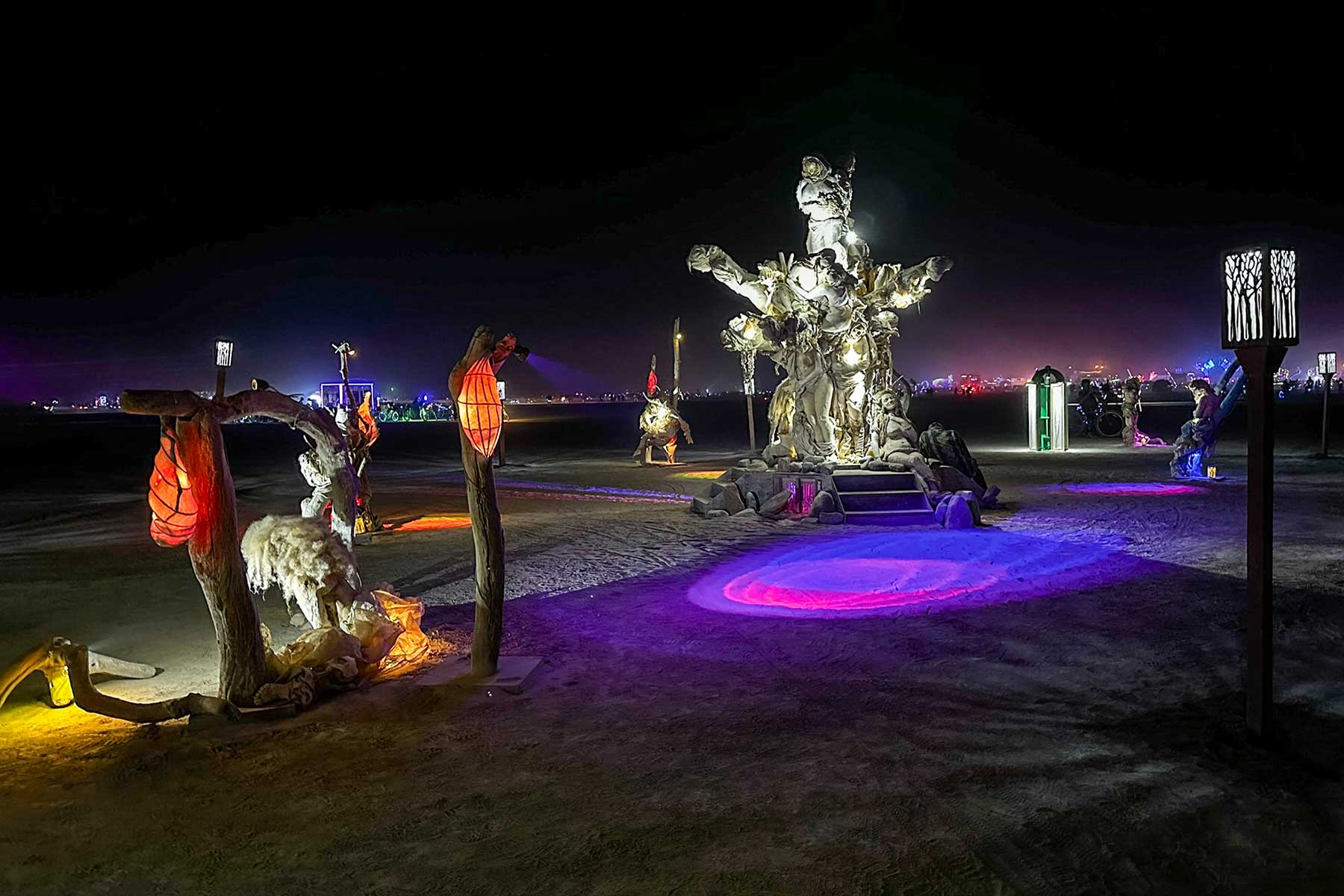 Wide night view of Womantree with red lanterns, a swing figure and purple light, city lights on the horizon