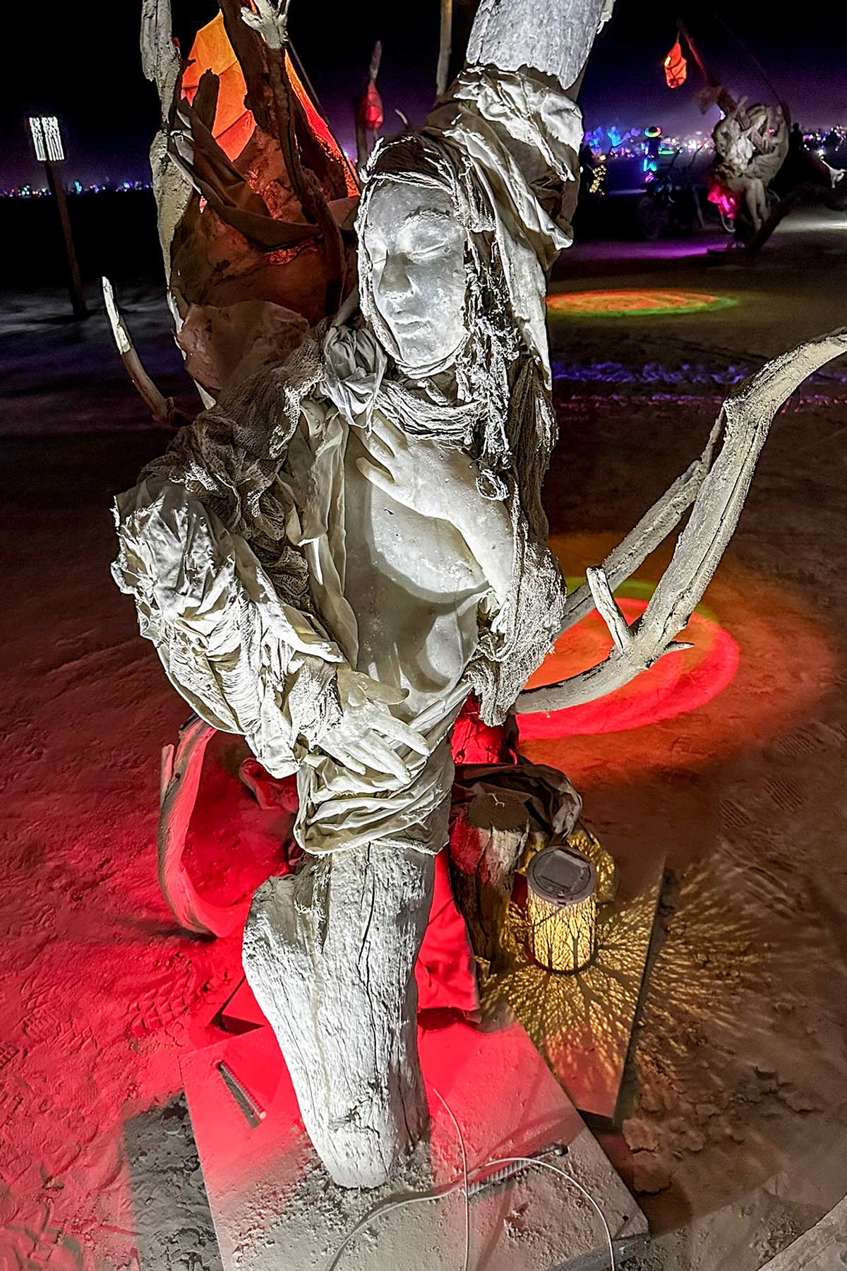 Cast figure of a woman archer bathed in red light at night