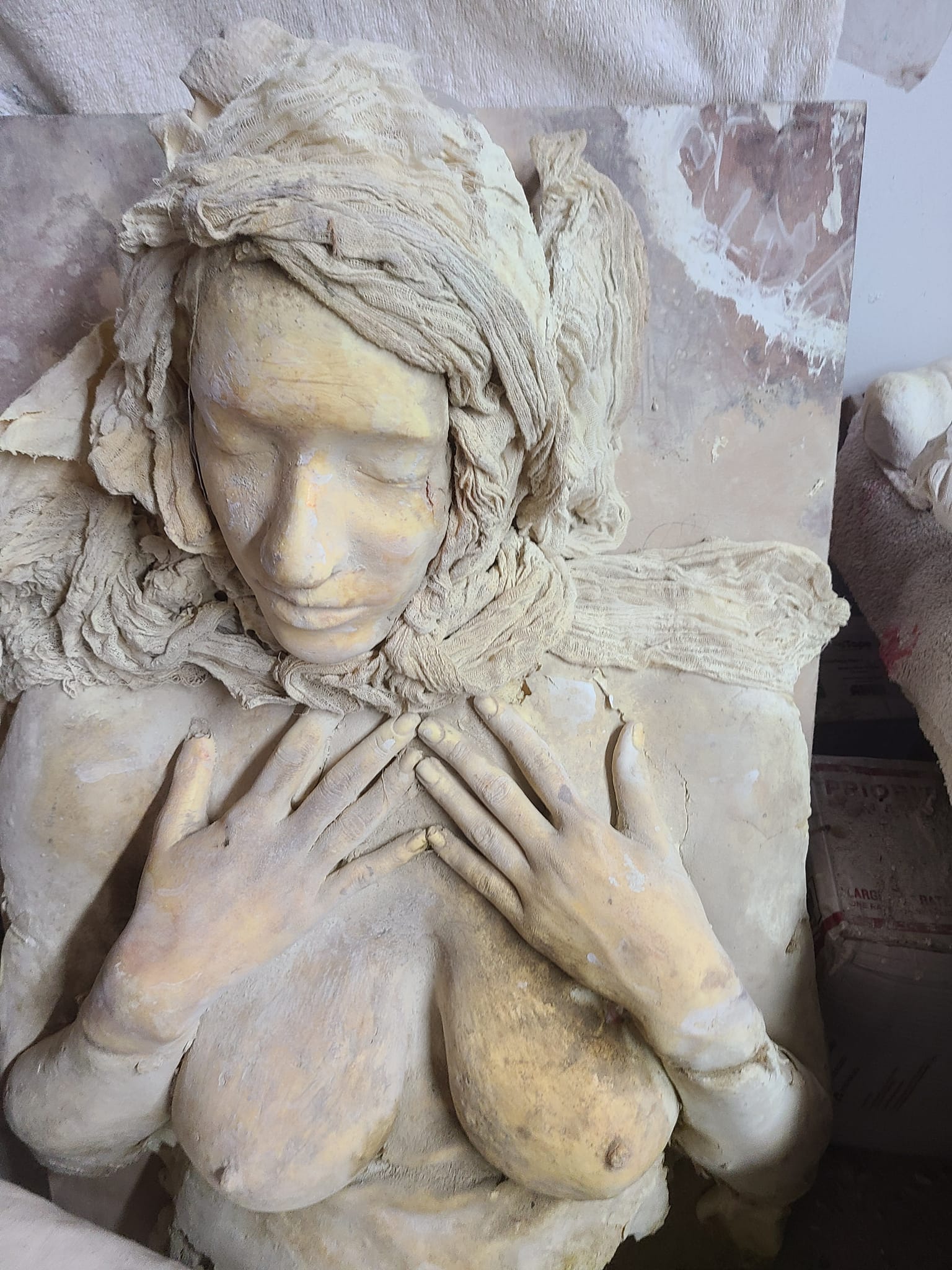 Cast relief of a woman with flowing hair and hands crossed over her chest