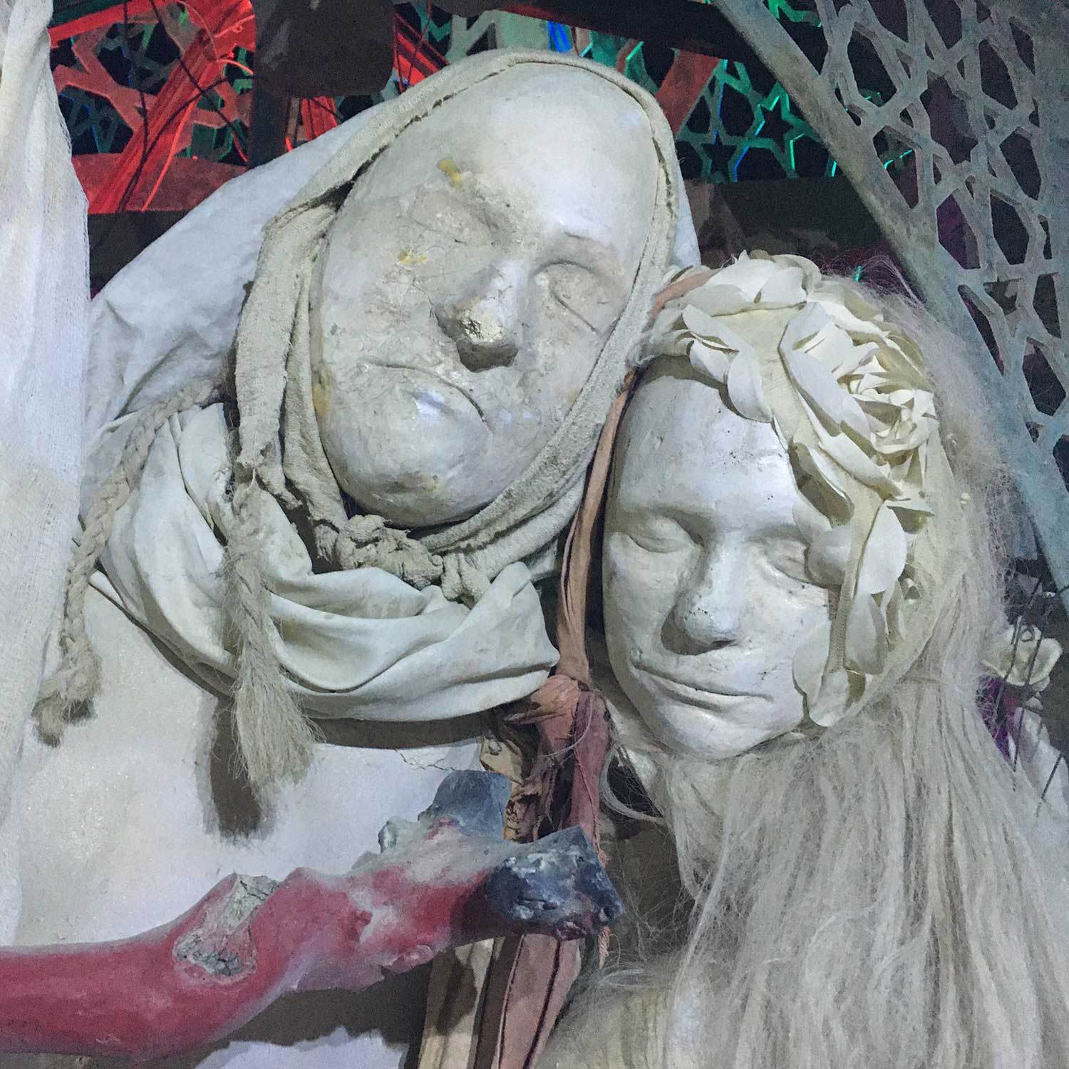 Two cast faces resting together, wrapped in draped cloth