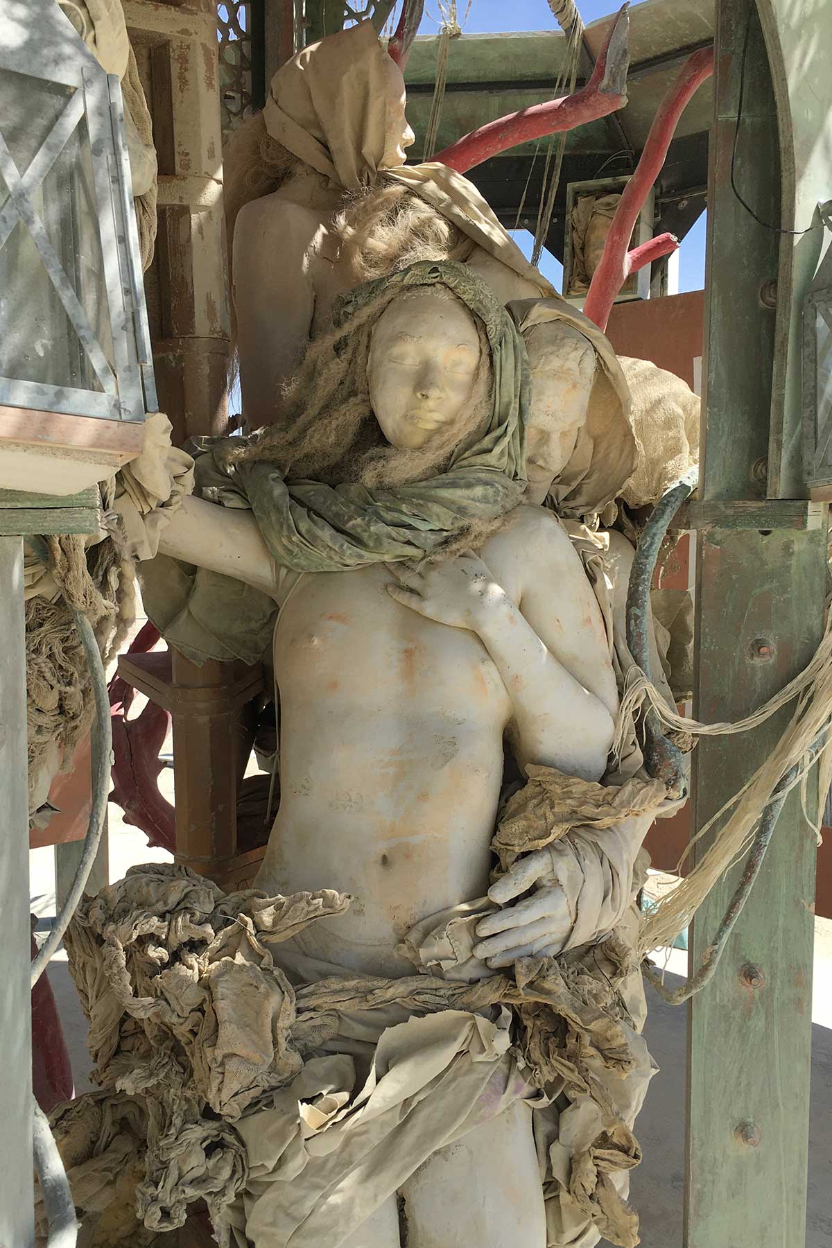 Draped cast figures standing within a wooden structure