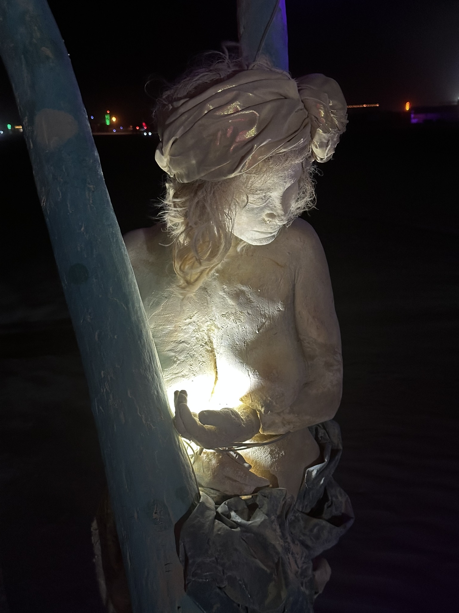 Cast figure holding a glowing light in her hands at night